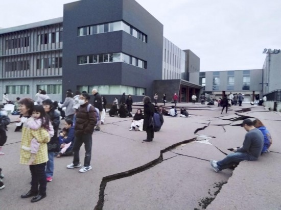 1月1日，在日本石川縣輪島市，人們站在被地震破壞的地面上。新華社/共同社