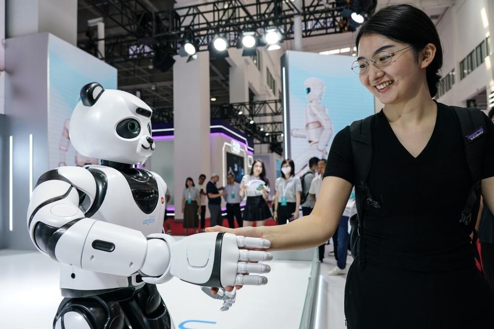 2023年8月16日，一名女士在北京舉辦的2023世界機(jī)器人大會現(xiàn)場與智能機(jī)器人握手。新華社記者彭子洋攝