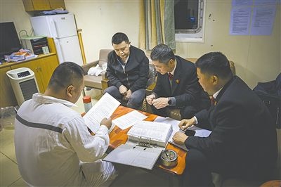 圖②：法官向船長講解相關法律規(guī)定，查看船舶資料，并與船方辦理扣押船舶的手續(xù)。