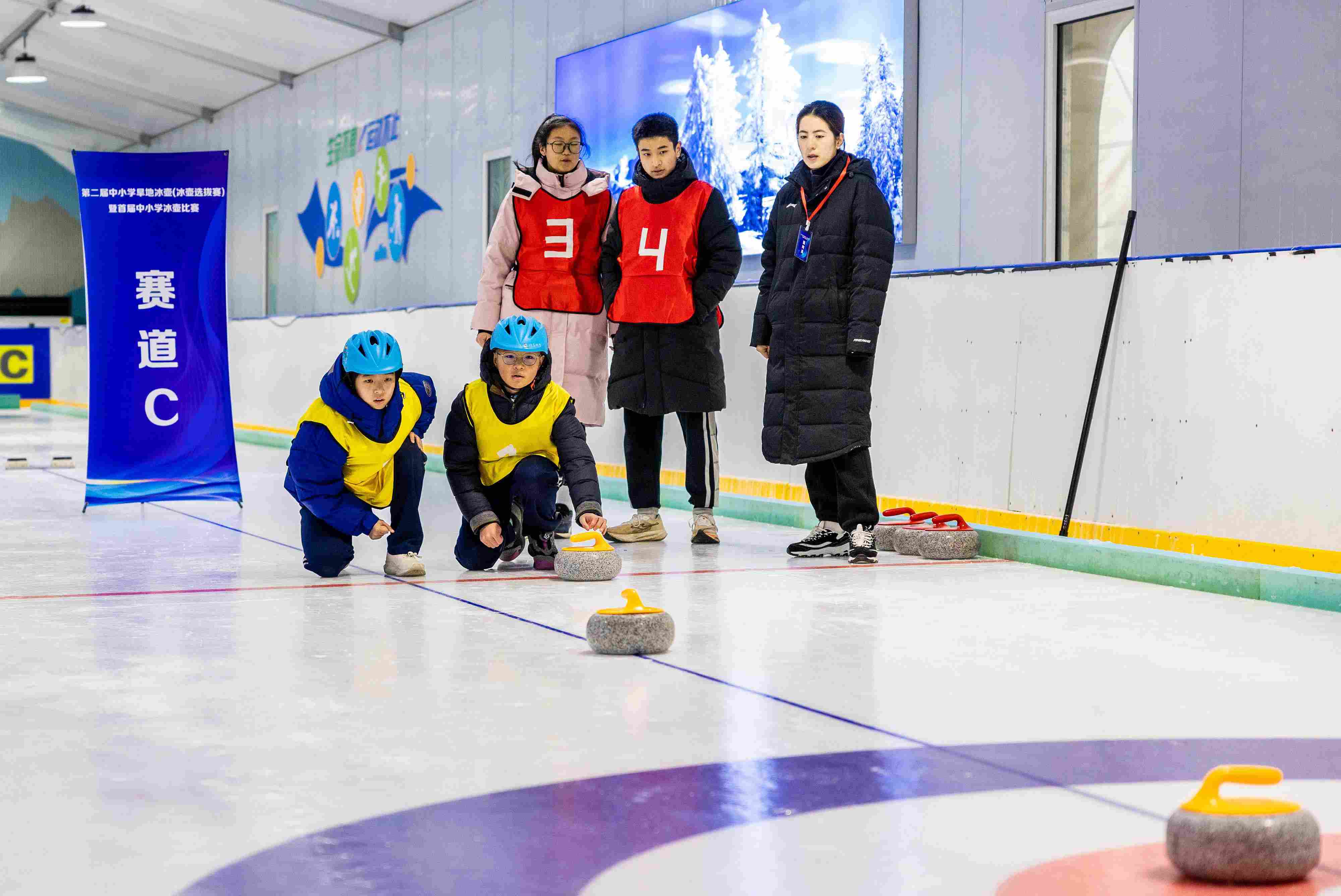 2023年12月10日，參賽選手在呼和浩特首屆中小學(xué)冰壺比賽中投擲冰壺。