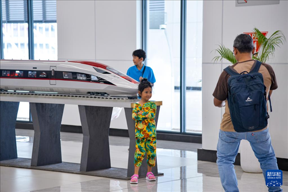 1月24日，在印度尼西亞雅加達(dá)哈利姆站候車大廳，一名小朋友和雅萬高鐵高速動(dòng)車組模型合影。新華社記者 徐欽 攝