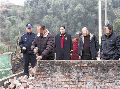  圖③：庭審結(jié)束后，在法官的見證下，陳某在院壩邊重新開鑿一條通道。