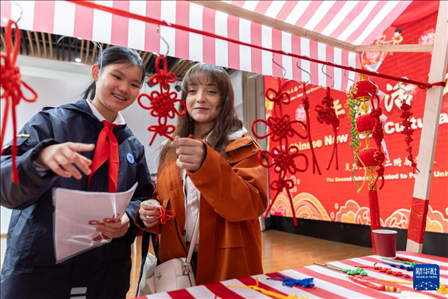 1月28日，復(fù)旦大學(xué)第二附屬學(xué)校學(xué)生（左）為美國馬斯卡廷中學(xué)學(xué)生（右）介紹中國結(jié)。 新華社記者 王翔 攝