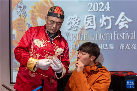 1月28日，在上海豫園舉行的民俗活動上，美國馬斯卡廷中學(xué)學(xué)生在非遺傳承人的指導(dǎo)下吹糖偶。 新華社記者 王翔 攝