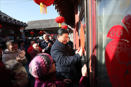 2019年2月1日上午，習近平總書記在前門東區(qū)草廠四條胡同32號院，高興地拿起一幅“?！弊郑H自貼到門上，給這里的老街坊們拜年。新華社記者鞠鵬攝
