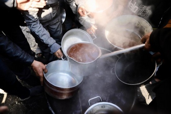  2月27日，在加沙地帶北部的杰巴利耶難民營，人們領(lǐng)取食物。新華社發(fā)（穆罕默德·阿里攝）