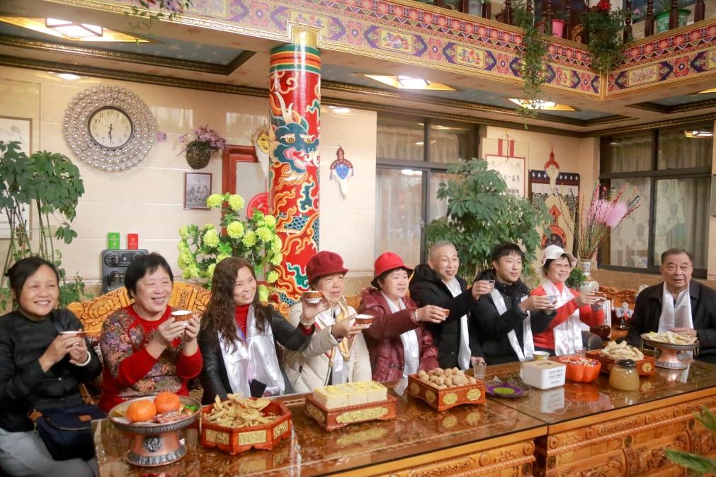 游客們?nèi)胱∶袼藓?，舉杯共飲酥油茶。新華社記者 邱星翔 攝