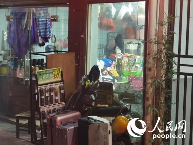 南寧“城中村”一裁縫鋪老板將電線從店內(nèi)拉出為電動自行車充電。人民網(wǎng) 覃心攝