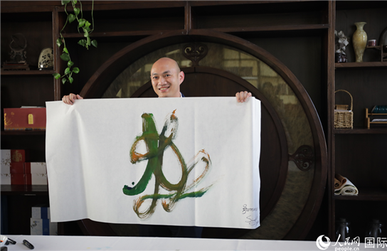 老撾駐華大使館三秘明君參加《五百筆·瀾湄合作》集體藝術(shù)創(chuàng)作。人民網(wǎng)王婧攝。