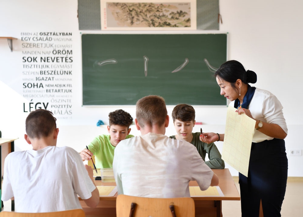 2023年2月24日，在匈牙利首都布達佩斯的匈中雙語學校，中國教師指導學生們學習書法。新華社記者 連漪 攝