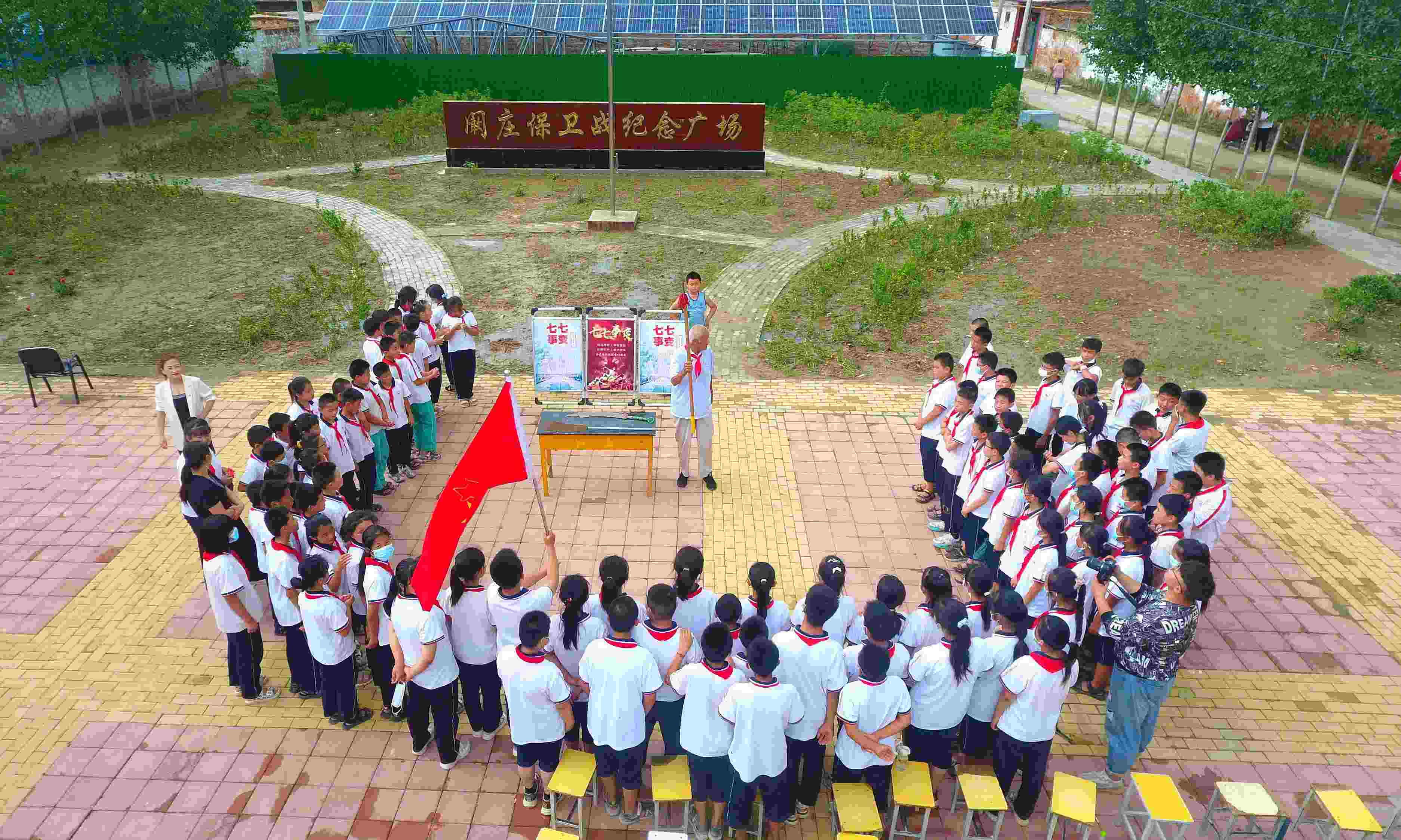 2022年7月6日，山東省聊城市，在茌平區(qū)菜屯鎮(zhèn)闞莊村的闞莊保衛(wèi)戰(zhàn)紀(jì)念廣場(chǎng)，闞莊保衛(wèi)戰(zhàn)親歷者王光木老人為小學(xué)生們講述抗戰(zhàn)故事，展示大刀、長矛。