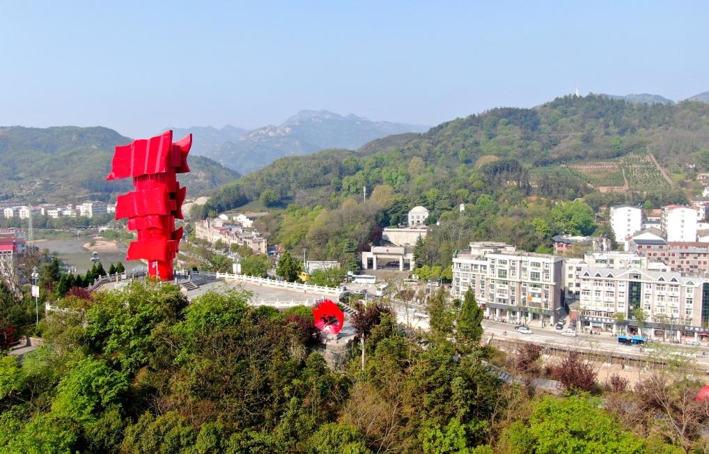 這是2021年4月9日拍攝的鄂豫皖蘇區(qū)首府革命博物館附近的英雄山上的“紅旗飄飄”主題雕塑（無人機照片）。新華社發(fā)
