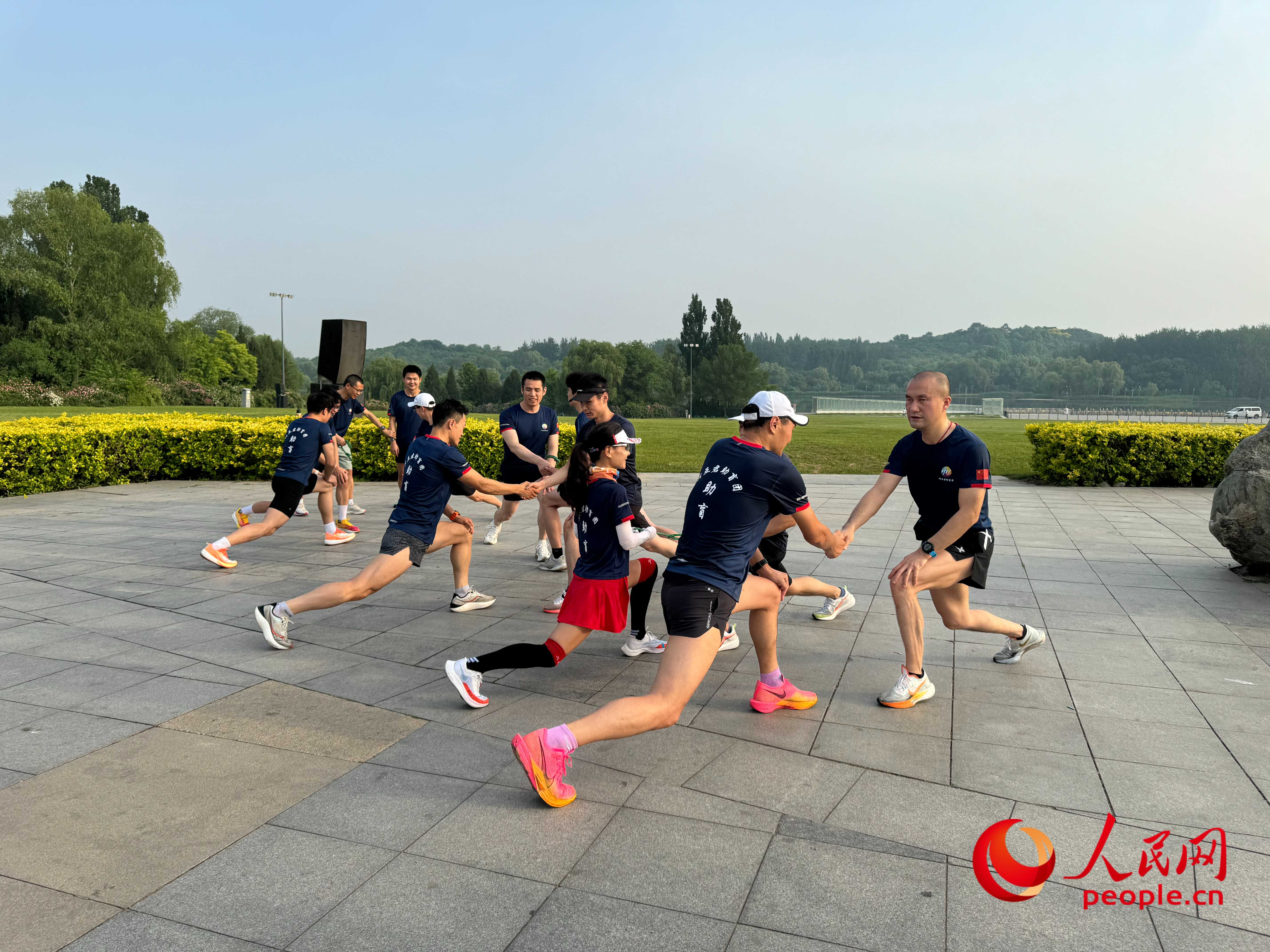 盲人和志愿者做跑步前準(zhǔn)備。人民網(wǎng) 周靜圓攝