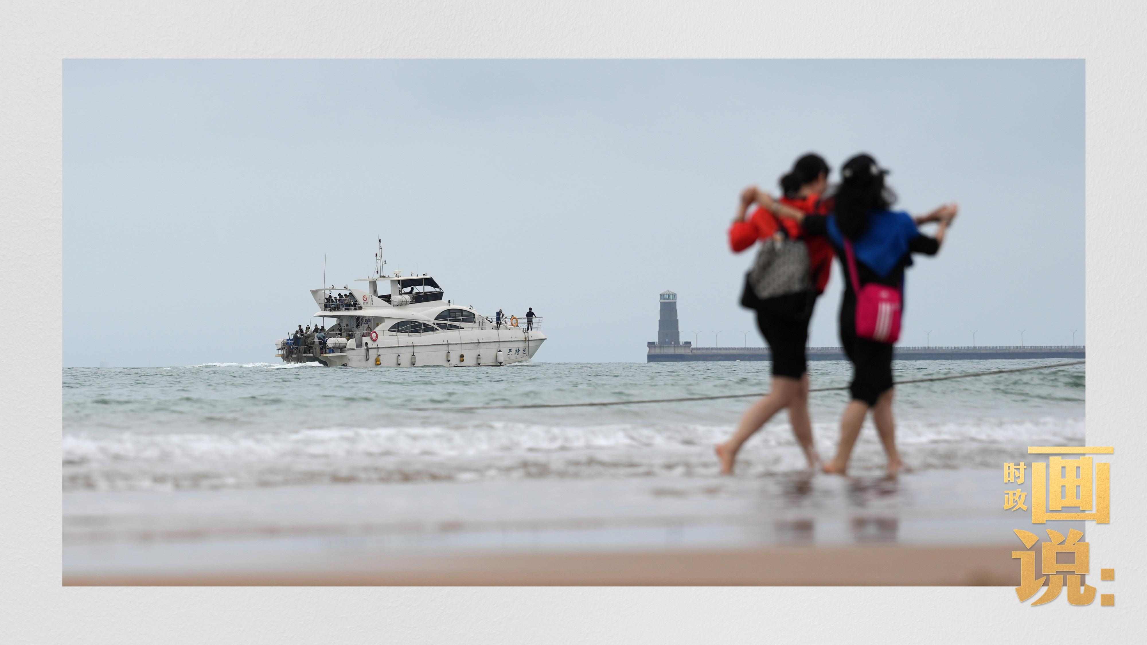 △日照陽光海岸綠道上的萬平口景區(qū)，一對游客在海浪中翩然起舞。