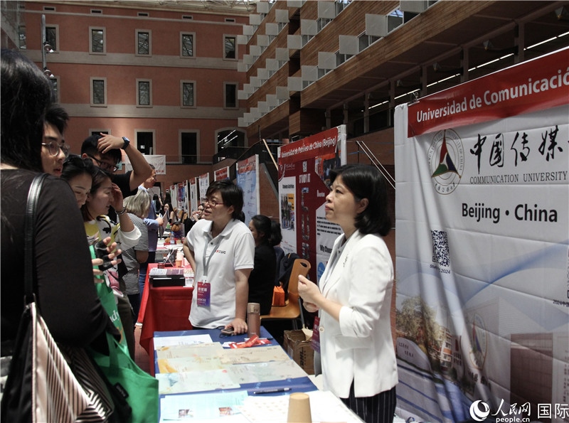 旅西華人華僑在展臺(tái)前咨詢。人民網(wǎng)記者 許海林?jǐn)z