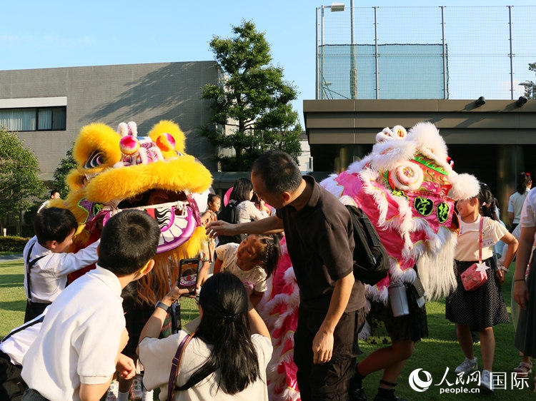 孩子們好奇地圍觀舞獅。人民網(wǎng) 許可攝