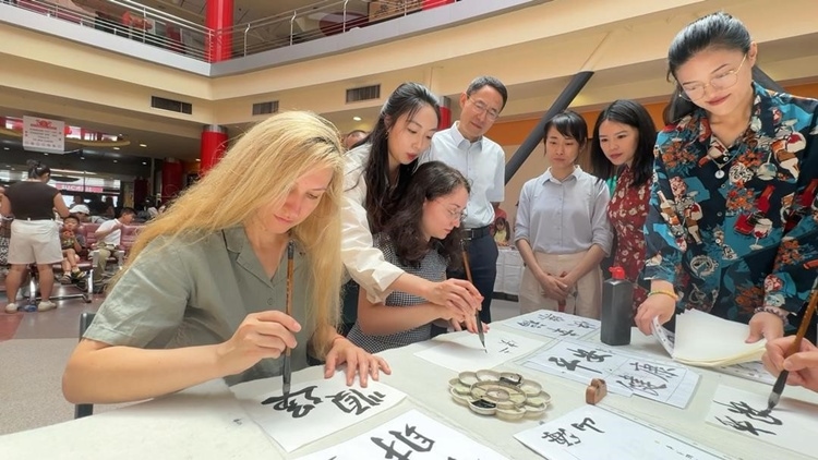 羅馬尼亞友人在活動現(xiàn)場學(xué)寫漢字。中國駐羅馬尼亞大使館領(lǐng)僑處供圖