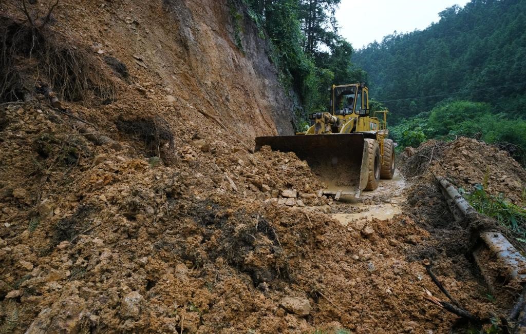 6月18日，在廣西融水苗族自治縣融水鎮(zhèn)新安村，一臺推土機在清理塌方路段。新華社發(fā)（龍林智攝）