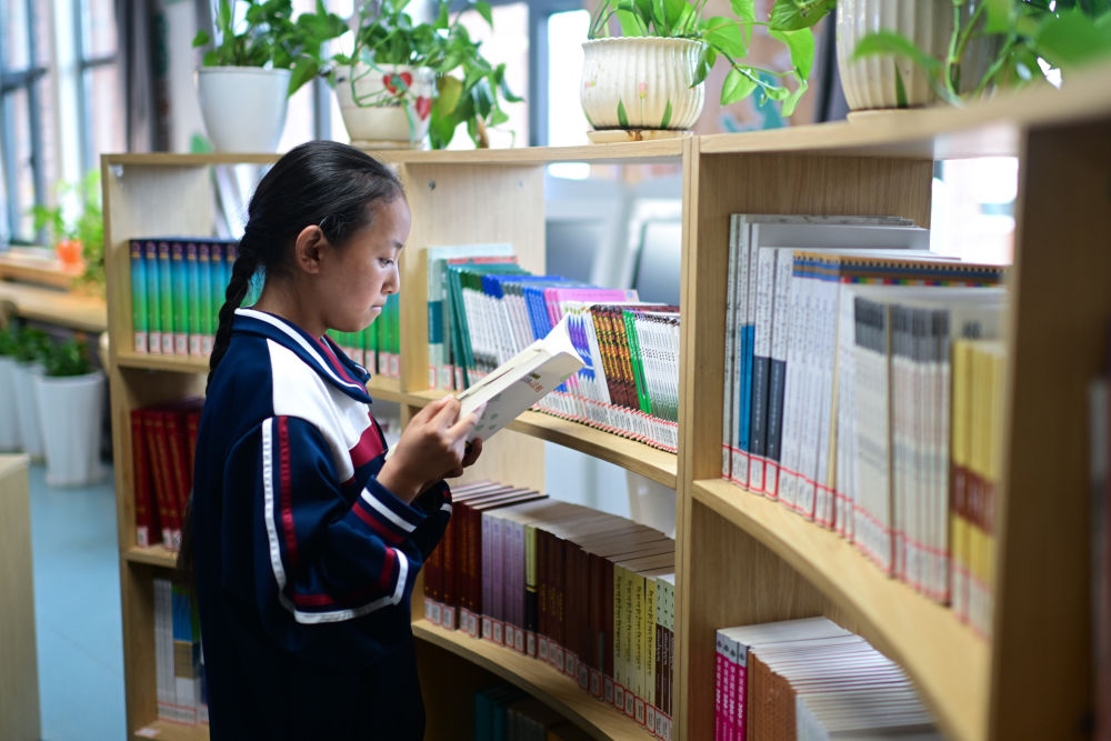 6月18日，果洛西寧民族中學學生尼東拉毛在圖書室看書。