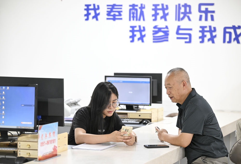 6月20日，在長城花園社區(qū)黨群服務(wù)中心，工作人員幫助居民辦理業(yè)務(wù)。