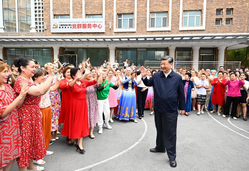 2022年7月13日，習近平總書記在新疆烏魯木齊市天山區(qū)固原巷社區(qū)考察時，向各族群眾揮手致意。