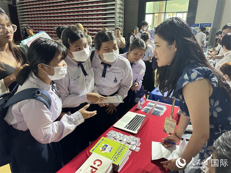來自泰國的學生、家長在教育展臺前咨詢。人民網(wǎng)記者 簡承淵攝