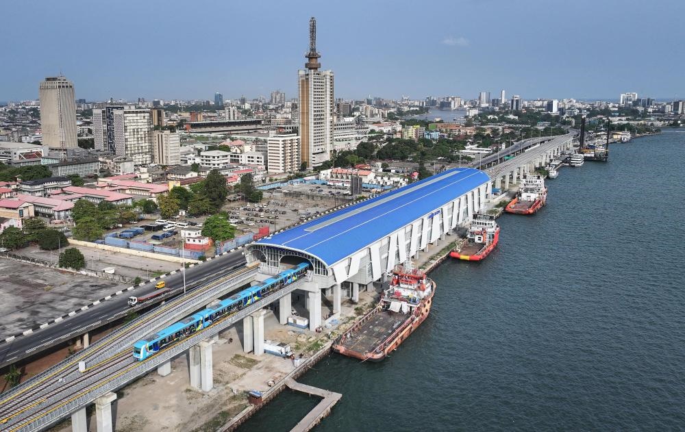 2024年3月2日，在尼日利亞拉各斯，一列輕軌藍(lán)線列車(chē)駛?cè)氪a頭站（無(wú)人機(jī)照片）。拉各斯輕軌藍(lán)線是西非地區(qū)首條由中國(guó)企業(yè)自主設(shè)計(jì)、建造、施工、運(yùn)營(yíng)的電氣化城市軌道交通項(xiàng)目。新華社記者 韓旭 攝