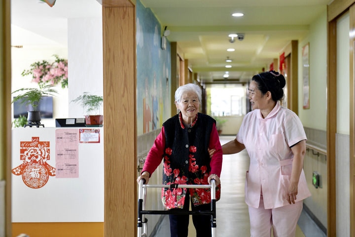 2024年5月25日，在山東省日照市東港區(qū)石臼街道日照幸福護(hù)理院，工作人員在陪護(hù)老人。新華社記者 郭緒雷 攝