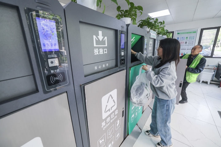 2024年4月10日，在浙江省湖州市吳興區(qū)飛英街道新華府小區(qū)內(nèi)，居民在垃圾分類智能系統(tǒng)的指導(dǎo)下進(jìn)行垃圾分類投放，居民的投放情況將實(shí)時(shí)匯總到智慧服務(wù)平臺，會有相應(yīng)的積分獎勵(lì)。新華社記者 徐昱 攝