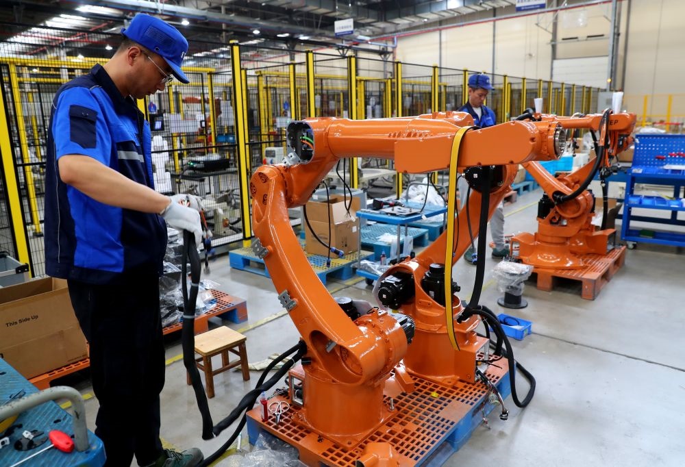 工作人員在上海新時(shí)達(dá)機(jī)器人有限公司位于嘉定的智能工廠內(nèi)忙碌（2024年5月23日攝）。新華社記者 龔兵 攝