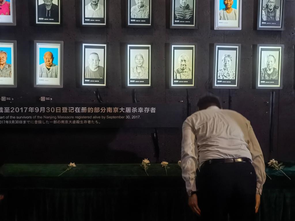 7月18日，人們向離世的南京大屠殺幸存者獻(xiàn)花、鞠躬。新華社記者邱冰清 攝