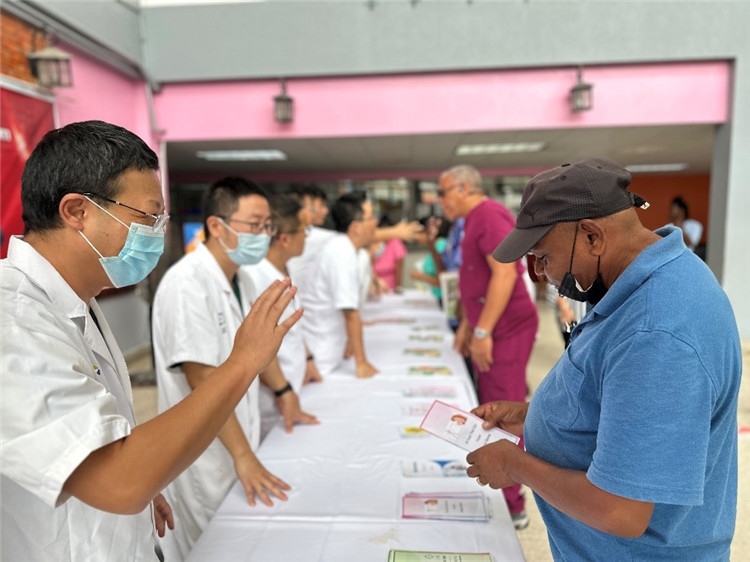 援圭醫(yī)療隊隊員們在啟動儀式上為當?shù)孛癖姺职l(fā)宣傳手冊。中國援助圭亞那醫(yī)療隊供圖
