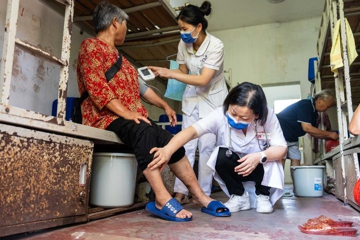 2024年7月30日，在湖南省湘潭縣河口中學(xué)安置點(diǎn)，醫(yī)務(wù)人員為受洪水影響而轉(zhuǎn)移安置的群眾檢查身體。 新華社記者 陳思汗 攝