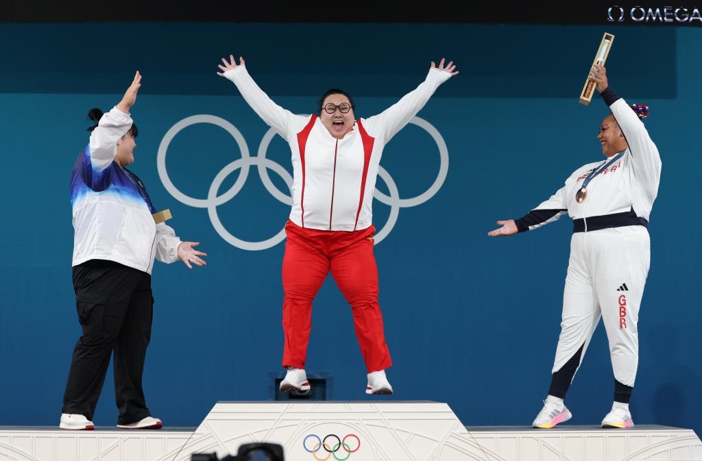 中國(guó)選手李雯雯（中）在巴黎奧運(yùn)會(huì)舉重女子81公斤以上級(jí)頒獎(jiǎng)儀式中登上領(lǐng)獎(jiǎng)臺(tái)（2024年8月11日攝）。新華社記者 楊磊 攝