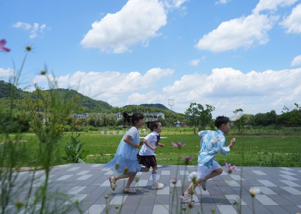 兒童在余姚市梁弄鎮(zhèn)的田野間奔跑（7月3日攝）。新華社記者翁忻旸 攝
