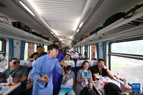 9月7日，相聲演員在S910列車上為旅客表演快板。