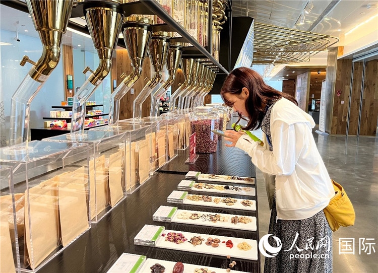 4. 代表團(tuán)團(tuán)員對新中式茶飲的食材充滿興趣。（人民網(wǎng)記者陳思 攝）