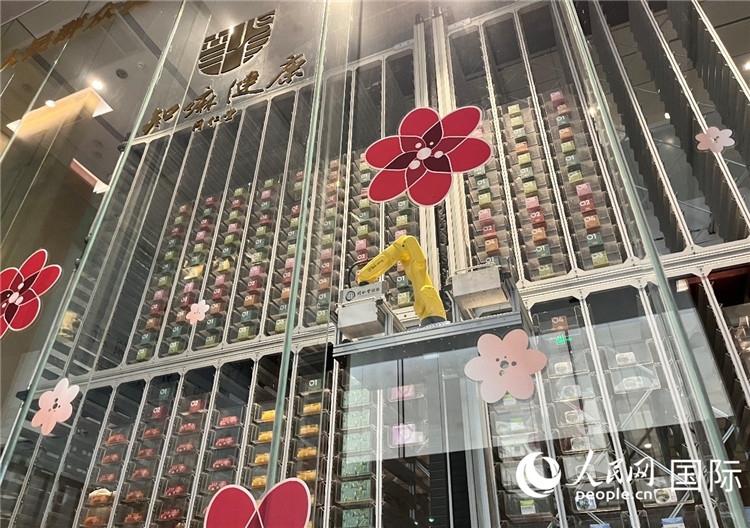 6. 機(jī)械臂正在取貨。（人民網(wǎng)記者陳思 攝）