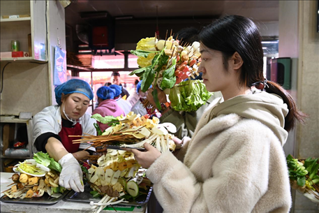 游客挑選好麻辣燙菜品后排隊(duì)等待加工。新華社記者 范培珅 攝