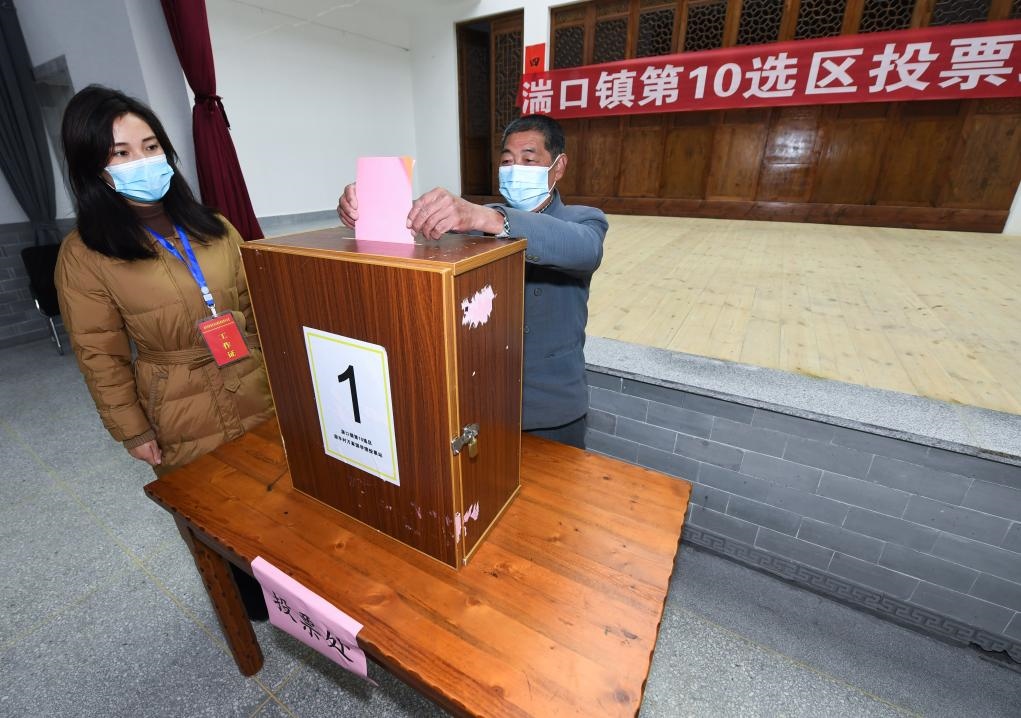 2021年12月14日，在浙江省杭州市臨安區(qū)湍口鎮(zhèn)迎豐村的基層投票點，村民在參加投票，村級監(jiān)察聯(lián)絡(luò)員監(jiān)票。新華社記者 徐昱 攝