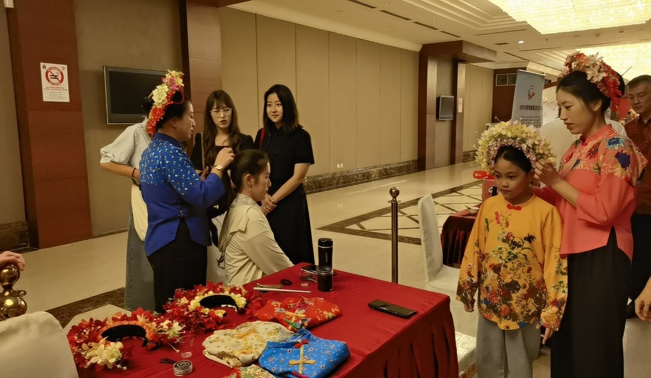 阿拉扎大學(xué)孔子學(xué)院志愿者老師向傳承人學(xué)習(xí)簪花圍。阿拉扎大學(xué)孔子學(xué)院供圖