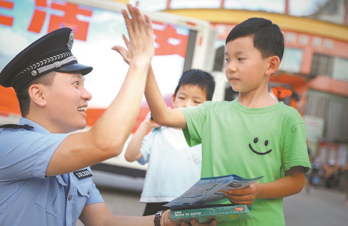 ▲7月10日，江西省吉安市公安局吉州分局組織民警深入轄區(qū)開展安全宣傳，民警向小朋友講解防溺水知識(shí)。朱文杰攝