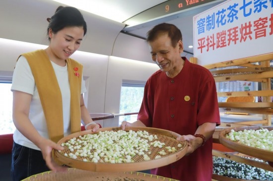 10月1日，福州市茉莉花茶窨制工藝代表性傳承人張子建與旅客在G1634次列車上制作茉莉花茶。新華社記者周義 攝