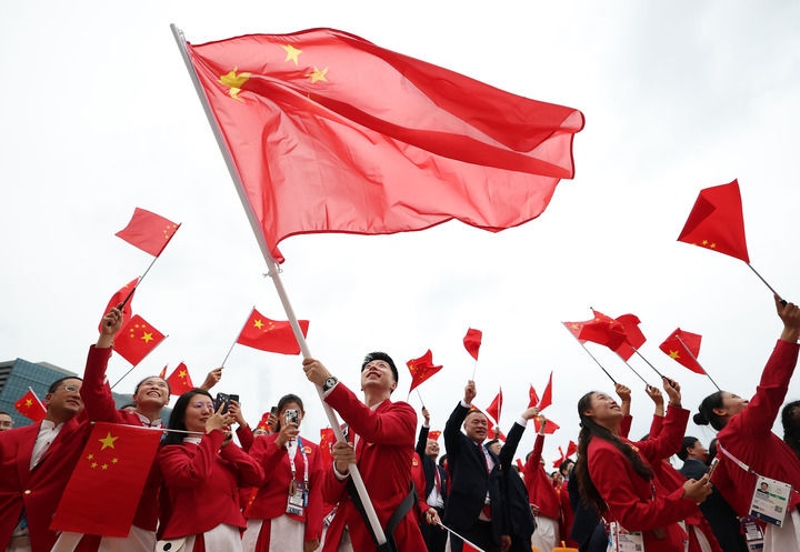 2024年7月26日，在法國巴黎舉行的第33屆夏季奧林匹克運(yùn)動會開幕式正式開始前，中國體育代表團(tuán)旗手揮舞國旗。新華社記者 曹燦 攝