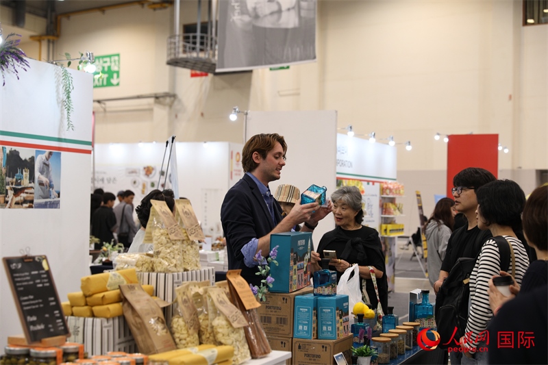 當(dāng)?shù)貢r(shí)間10月5日，在第21屆釜山國際美食博覽會(huì)上，意大利展商向參觀者們介紹的意大利食品。人民網(wǎng)記者 莽九晨攝
