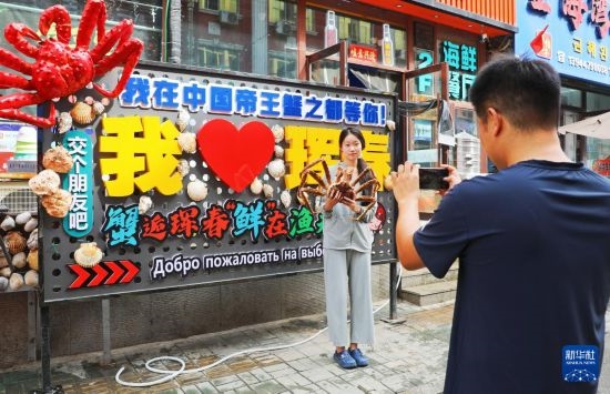9月21日，游客在吉林省琿春市一處帝王蟹元素主題裝飾前拍照留念。新華社發(fā)