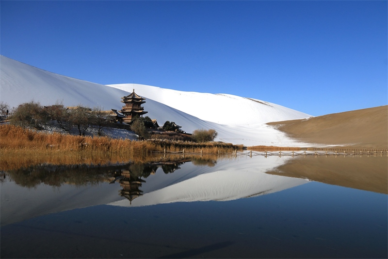 鳴沙山月牙泉景區(qū)雪景。敦煌市委宣傳部供圖，張曉亮攝