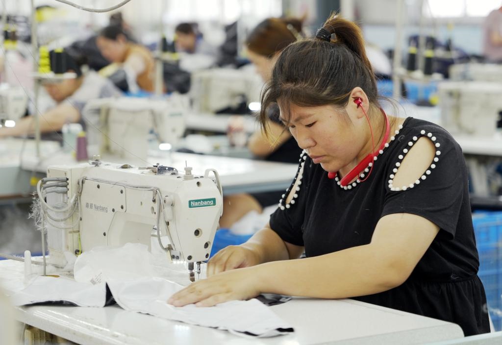 5月20日，村民在李寨村服裝加工廠內(nèi)忙碌。河南省周口市沈丘縣馮營鎮(zhèn)李寨村地處豫東平原。近年來，乘著脫貧攻堅與鄉(xiāng)村振興政策的東風，李寨村積極探索產(chǎn)業(yè)發(fā)展模式，通過“龍頭企業(yè)+村集體經(jīng)濟+農(nóng)戶”的方式，逐漸發(fā)展形成肉牛養(yǎng)殖、設施農(nóng)業(yè)、服裝加工、康養(yǎng)民宿等產(chǎn)業(yè)，以產(chǎn)業(yè)振興助力鄉(xiāng)村振興。新華社記者 李嘉南 攝