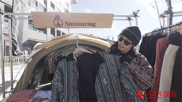 藤田周正在展示自己設(shè)計的滑雪服。人民網(wǎng)記者 袁蒙攝