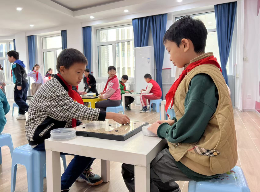 學(xué)生們?cè)谏傧汝?duì)大廳下圍棋。人民網(wǎng) 白炅攝